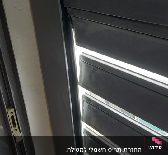 תריסים אפורים עם אור חודר ביניהם